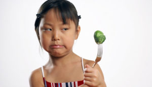 Girl who is disgusted at a brussels sprout
