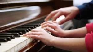 Two people playing the piano