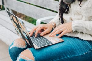 girl on bench doing online college