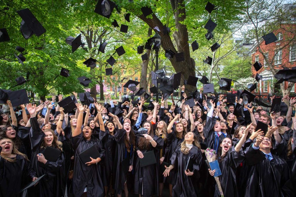 graduates toss their caps in the air